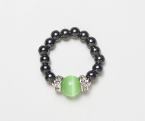 black beaded stretch ring with light green cats eye accent bead